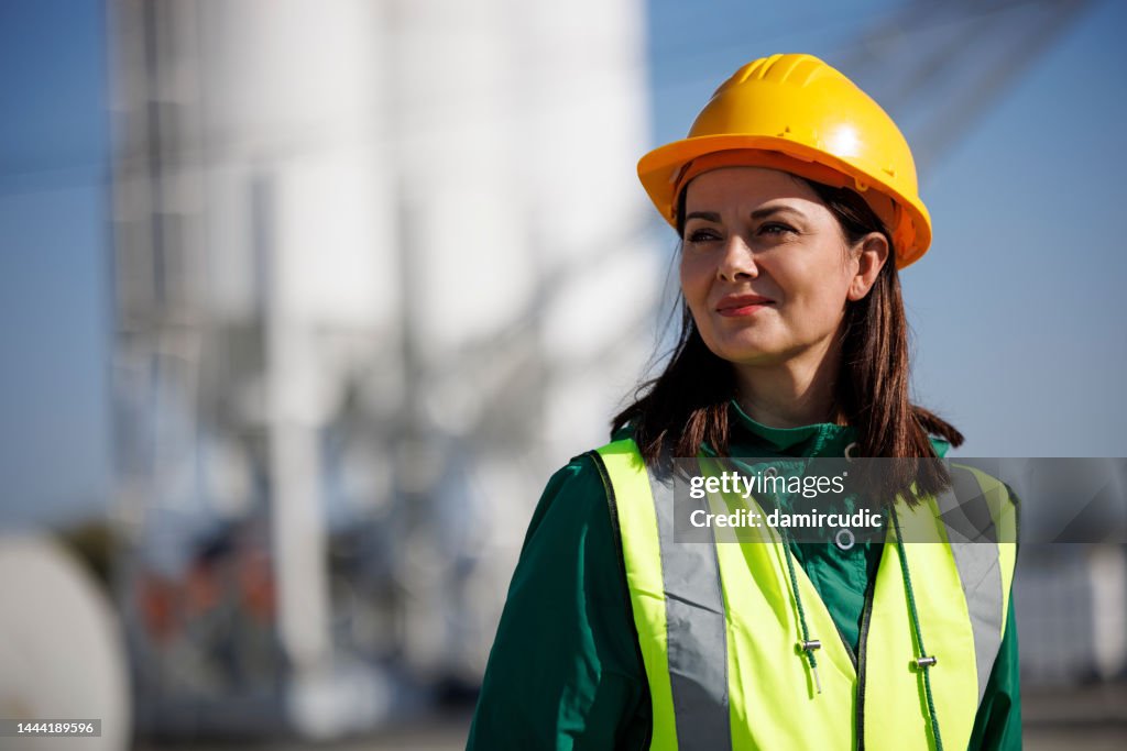 Portrait of female engineer with hardhat at factory industry workplace