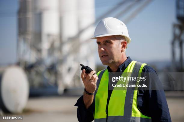 porträt eines ingenieurs mit walkie-talkie in einer industrieanlage - cb funk stock-fotos und bilder