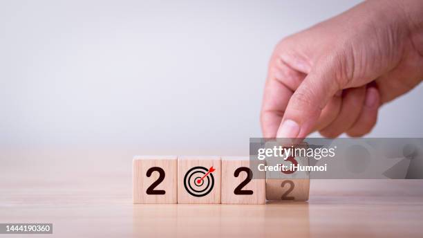 2023 Strategy, Business, Plan, Growth, Investment, Target, Goal, Success, Development, Background Concept. Businessman hand flipping wooden cube block change year 2022 to 2023 with goal, target symbol strategy business plan growth investment target