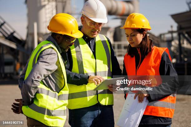 ingenieros hablando en instalaciones industriales - builder fotografías e imágenes de stock