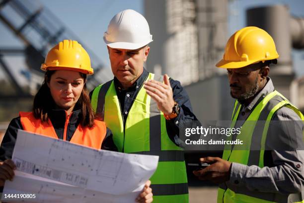 ingenieure diskutieren, in industriellen center - business man overseeing blueprints outdoor stock-fotos und bilder