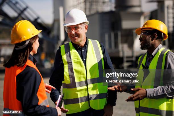 three multi-ethnic engineers chatting at industrial facility - project manager stock pictures, royalty-free photos & images