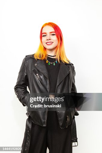Studio portrait of an 18 year old white woman with brightly dyed hair in a black leather jacket against a white background Studio portrait of an 18 year old white woman with brightly dyed hair in a black leather jacket against a white background