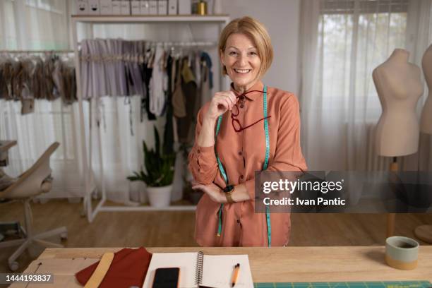 smiling middle aged woman in a fashion office - celebrity stylist stock pictures, royalty-free photos & images