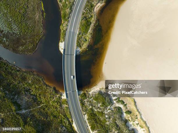 overhead view car on road crossing over river mouth on coastline - africa road stock pictures, royalty-free photos & images