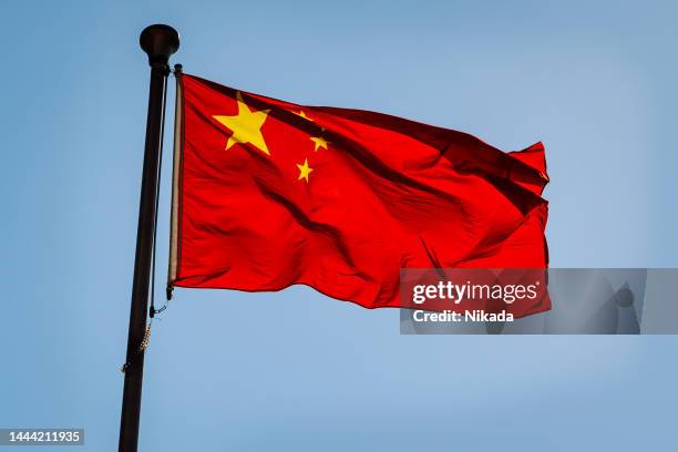 chinese national flag against blue sky - chinese vlag stockfoto's en -beelden