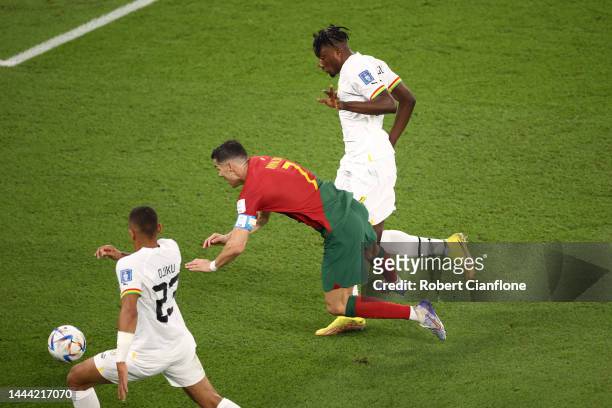 Cristiano Ronaldo of Portugal is brought down by Mohammed Salisu of Ghana during the FIFA World Cup Qatar 2022 Group H match between Portugal and...