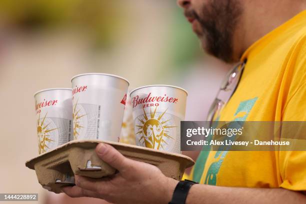 Brazil supporters carry cups of alcohol-free beer marked "Budweiser Zero" in the stands ahead of the FIFA World Cup Qatar 2022 Group G match between...
