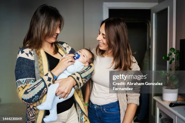 woman visiting sister with newborn child - sisters stock-fotos und bilder