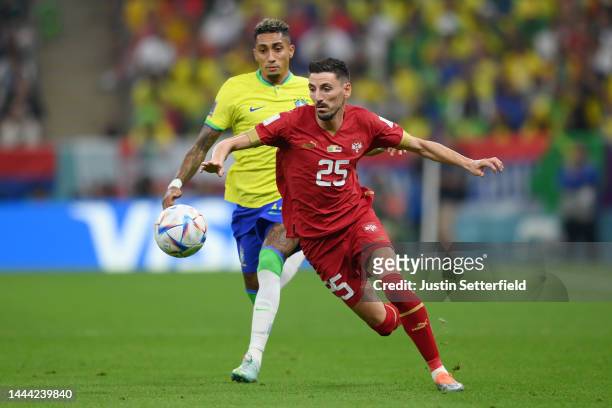Filip Mladenovic of Serbia battles for possession with Raphinha of Brazil during the FIFA World Cup Qatar 2022 Group G match between Brazil and...