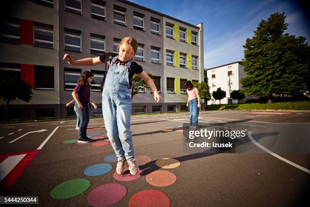 school kids playing in the playground - schoolplein stockfoto's en -beelden