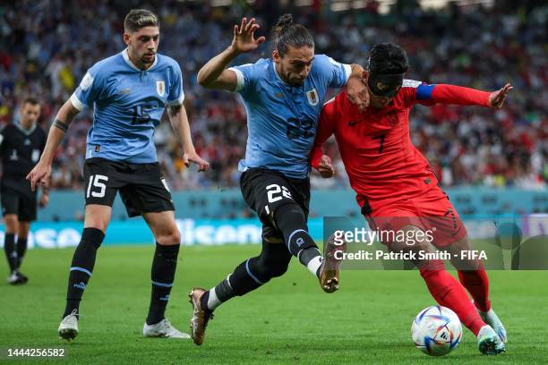 Heungmin Son of Korea Republic battles for possession with Martin Caceres of Uruguay during the FIFA World Cup Qatar 2022 Group H match between...