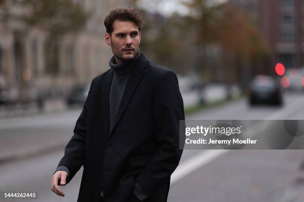 Felix Hartmann wearing a grey Aylin Koenig sweater & suit and black Bottega Veneta boots on November 18, 2022 in Hamburg, Germany.