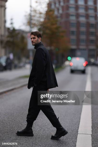 Felix Hartmann wearing a grey Aylin Koenig sweater & suit and black Bottega Veneta boots on November 18, 2022 in Hamburg, Germany.