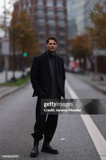 Felix Hartmann wearing a grey Aylin Koenig sweater & suit and black Bottega Veneta boots on November 18, 2022 in Hamburg, Germany.