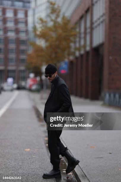 Felix Hartmann wearing a black Saint Laurent shades, black Zara knit hat, grey Aylin Koenig sweater & suit and black Bottega Veneta boots on November...