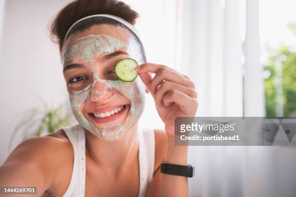 beautiful teenage girl getting a face mask with cucumbers in home - one teenage girl only bildbanksfoton och bilder