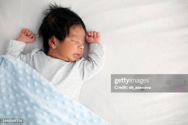 african american newborn baby sleeping on a white mattress - newborn sleeping stock pictures, royalty-free photos & images