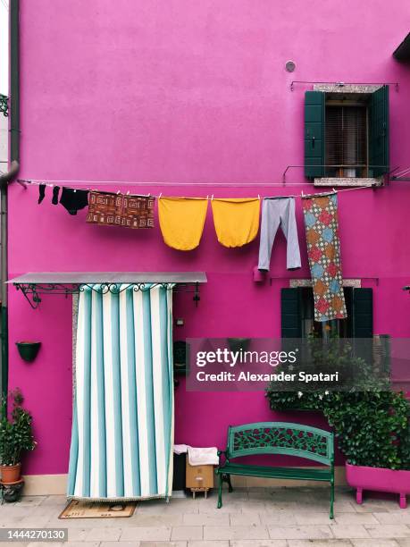 multi-colored vibrant houses on burano island near venice, italy - italy purple flowers village stock pictures, royalty-free photos & images