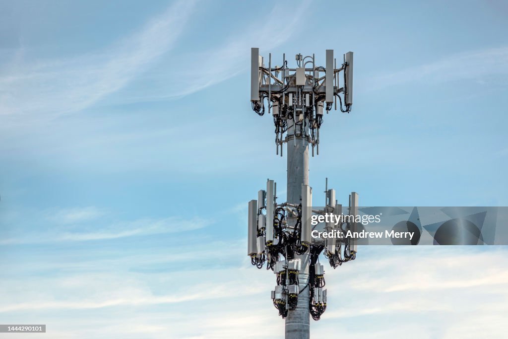 Communications cell tower mobile phone data blue sky clouds