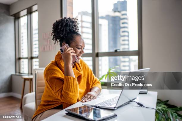 black woman talking on the phone at home - using laptop at home happy copy space stock pictures, royalty-free photos & images