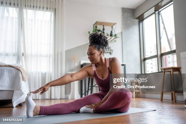 black woman stretching at home - black woman yoga stock pictures, royalty-free photos & images