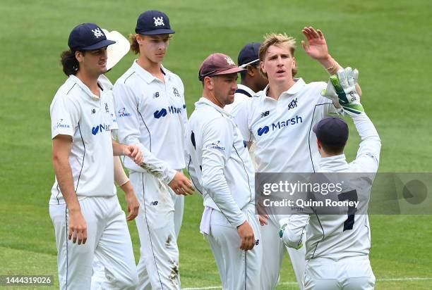 Will Sutherland of Victoria is congratulated by team mates for getting the wicket of Jake Doran of Tasmania during the Sheffield Shield match between...