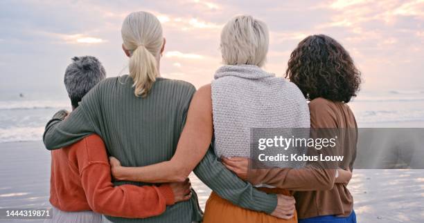 senior women, back view and friends on beach holiday, vacation or trip outdoors. retirement, travel and elderly group of people hug enjoying quality time together and having fun at seashore or coast. - only women hugging stock pictures, royalty-free photos & images