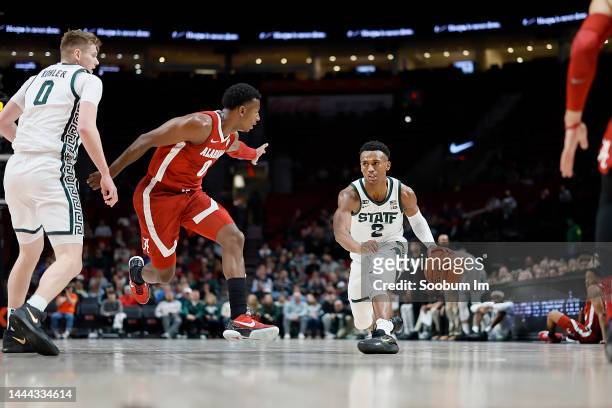Tyson Walker of the Michigan State Spartans controls the ball as Jaden Bradley of the Alabama Crimson Tide defends during the first half at Moda...