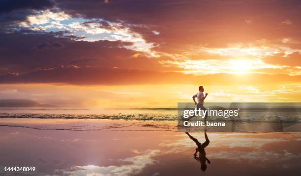 asian young man running on the beach at sunset - barefoot running stock pictures, royalty-free photos & images