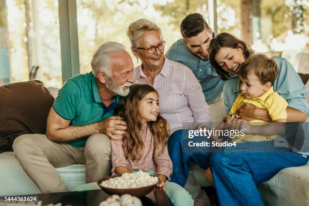 family popcorn and sofa time - family time stock pictures, royalty-free photos & images