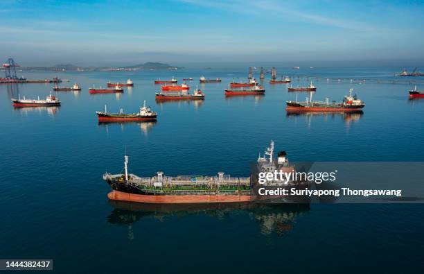 aerial view oil ship tanker park on the sea at dusk waiting for load or unload oil at loading dock from refinery, energy or oil industry concept. - oil tanker stock-fotos und bilder