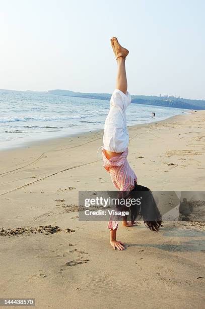 woman doing yoga on the beach side - yoga goa woman stock pictures, royalty-free photos & images