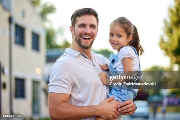 cute little girl in her father's arm outdoors - guy girl street laugh stock pictures, royalty-free photos & images