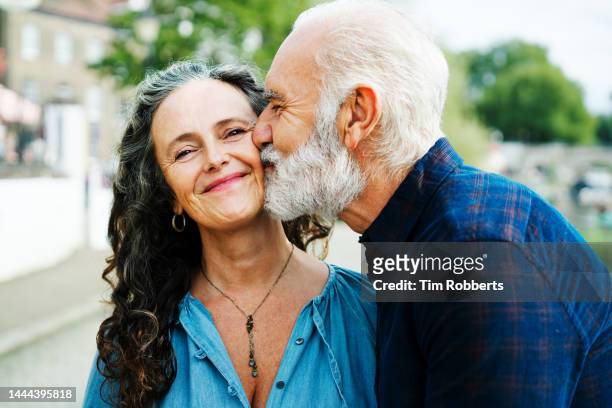 man kissing woman partner on cheek - casal beijando na rua imagens e fotografias de stock
