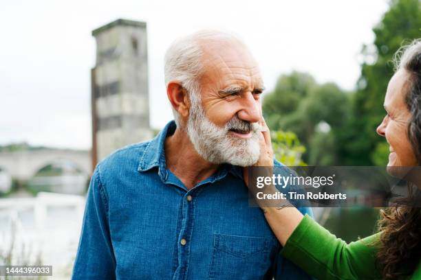 woman holding mans face, affectionate moment - survivers stock pictures, royalty-free photos & images