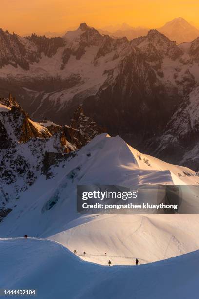 group of people climbing snow covered mountain on sunrise. - aiguille de midi imagens e fotografias de stock