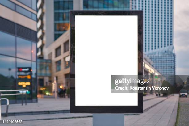 blank city format (lightposter, citylight) banner standing separately pylon in the modern city mockup. shopping centre, shop windows, high-rise business buildings on blurred background. - billboard photos et images de collection