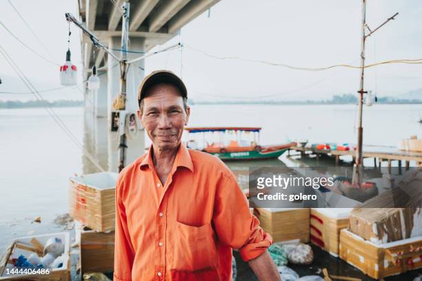 portrait of senior fisherman  at fish market in vietnam - fisherman stock pictures, royalty-free photos & images
