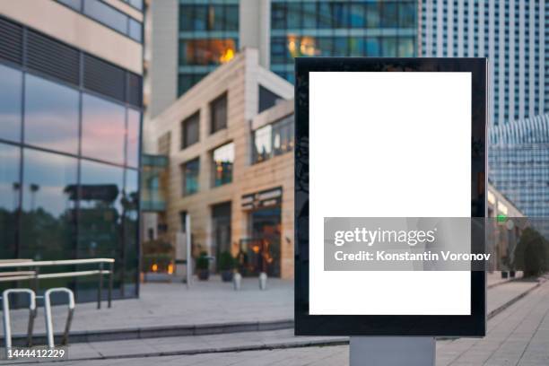 blank city format (lightposter, citylight) banner pylon in the modern city mockup. shopping centre, shop windows, bike parking, high-rise business buildings on blurred background. outdoor advertising - electronic billboard stock pictures, royalty-free photos & images