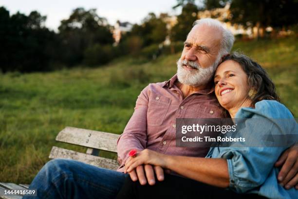 man and woman on bench, holding hands - falling in love stock pictures, royalty-free photos & images