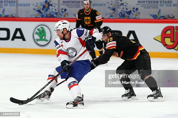 Alex Barta of Germany and Jonas Holos of Norway battle for the puck during the IIHF World Championship group S match between Germany and Norway at...