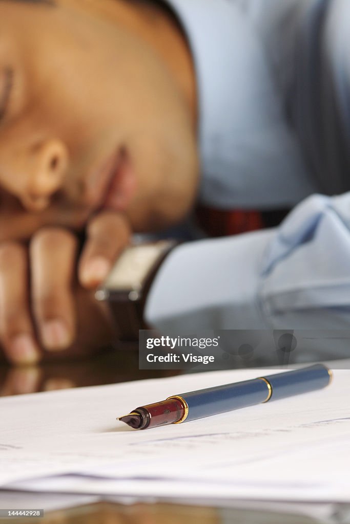 A business man sleepin over pending work