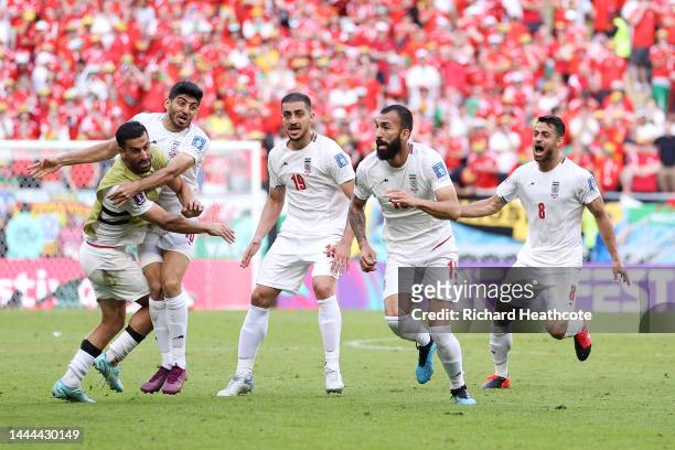 Roozbeh Cheshmi of IR Iran celebrates with teammates after scoring their team's first goal during the FIFA World Cup Qatar 2022 Group B match between...