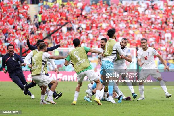 Roozbeh Cheshmi of IR Iran celebrates with teammates after scoring their team's first goal during the FIFA World Cup Qatar 2022 Group B match between...