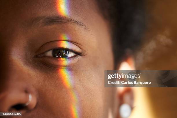 close up photo of multi coloured light falling on human eye. - close up woman eyes stock-fotos und bilder