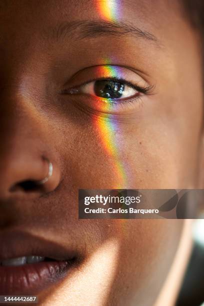 close up photo of multi coloured light falling on female human face. - iris mann stock-fotos und bilder