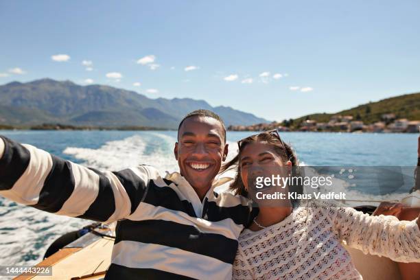 happy young couple taking selfie in boat - travel stock-fotos und bilder