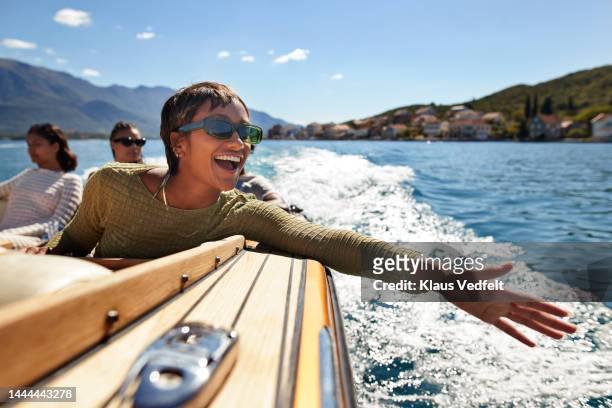 cheerful young woman enjoying motorboat ride - travel stock-fotos und bilder