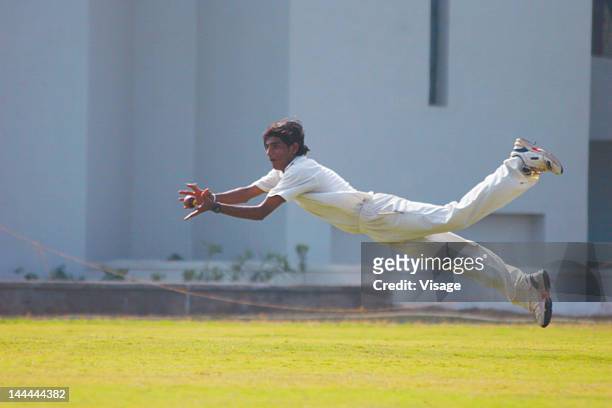 a fielder in action - cricket catch stock pictures, royalty-free photos & images